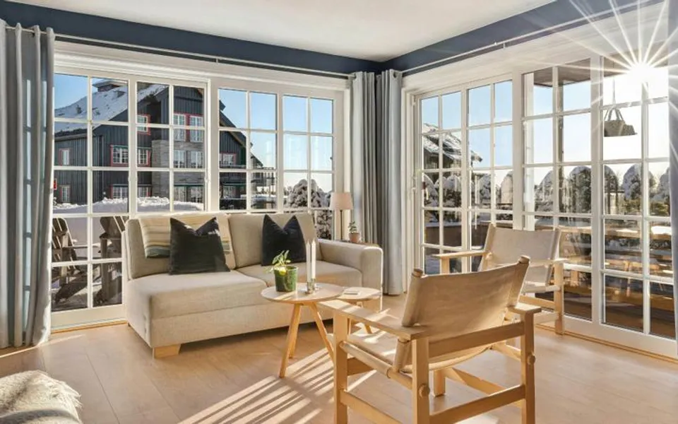 A bright living room with windows and a ceiling fan
